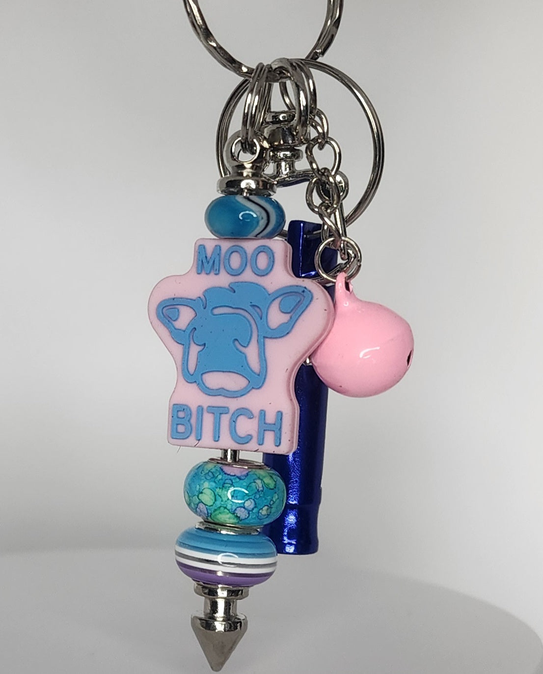Keychain with colorful beads and a cow-shaped tag on a white background