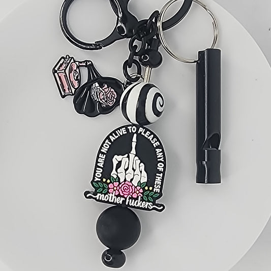 Keychain with a focal bead that says "You Are Not Alive to Please Any of These Mother Fuckers" with a skeletal hand flipping the bird on a white background.