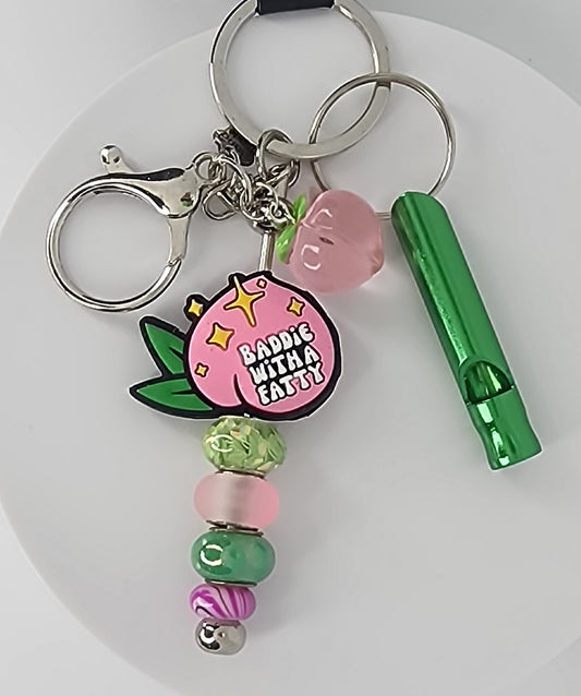 Peachy booty with matching green and pink beads, a peach charm, and a green whistle.