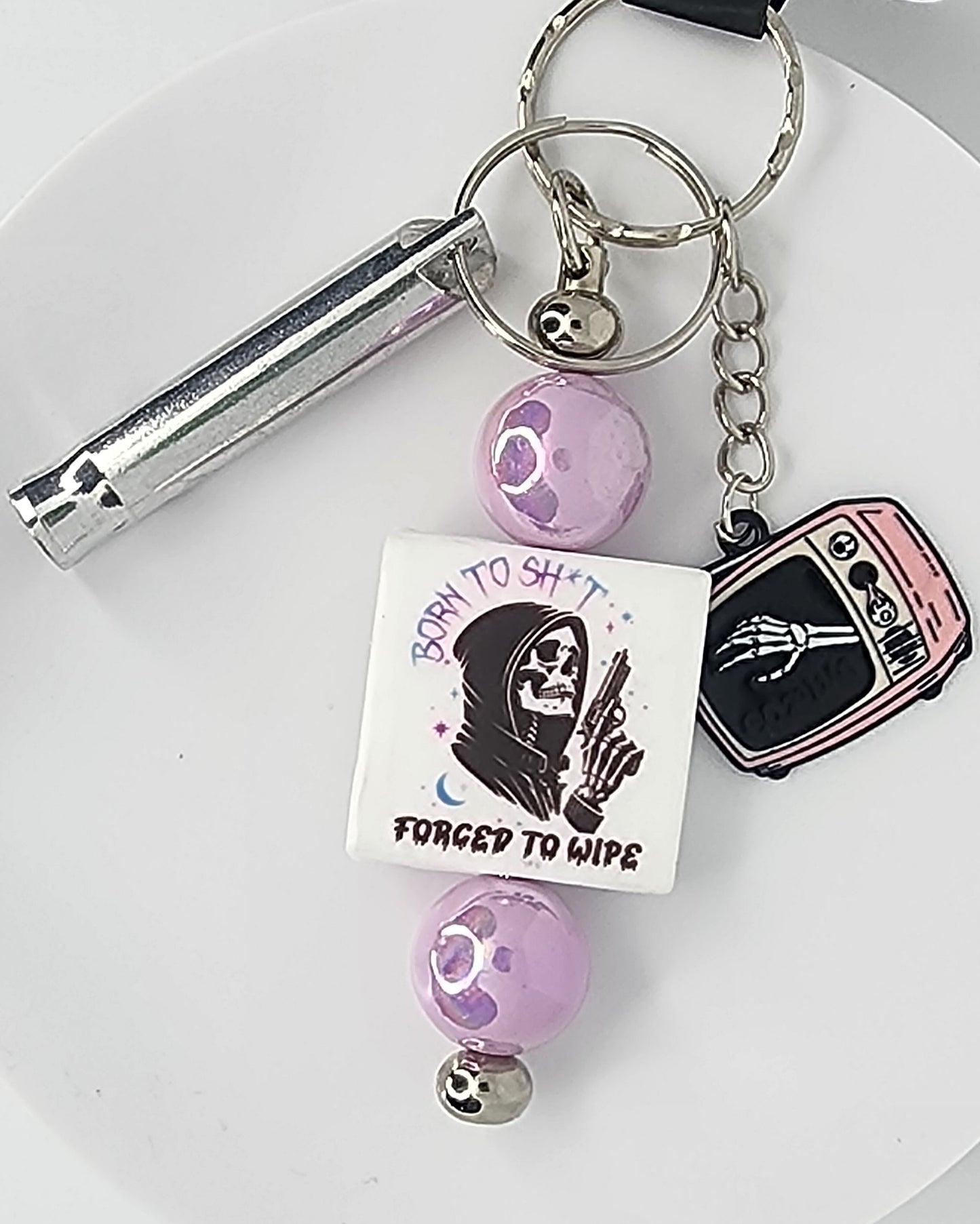Keychain with various charms including a skeleton and text on a white background
