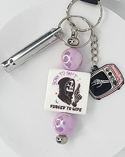 Keychain with various charms including a skeleton and text on a white background