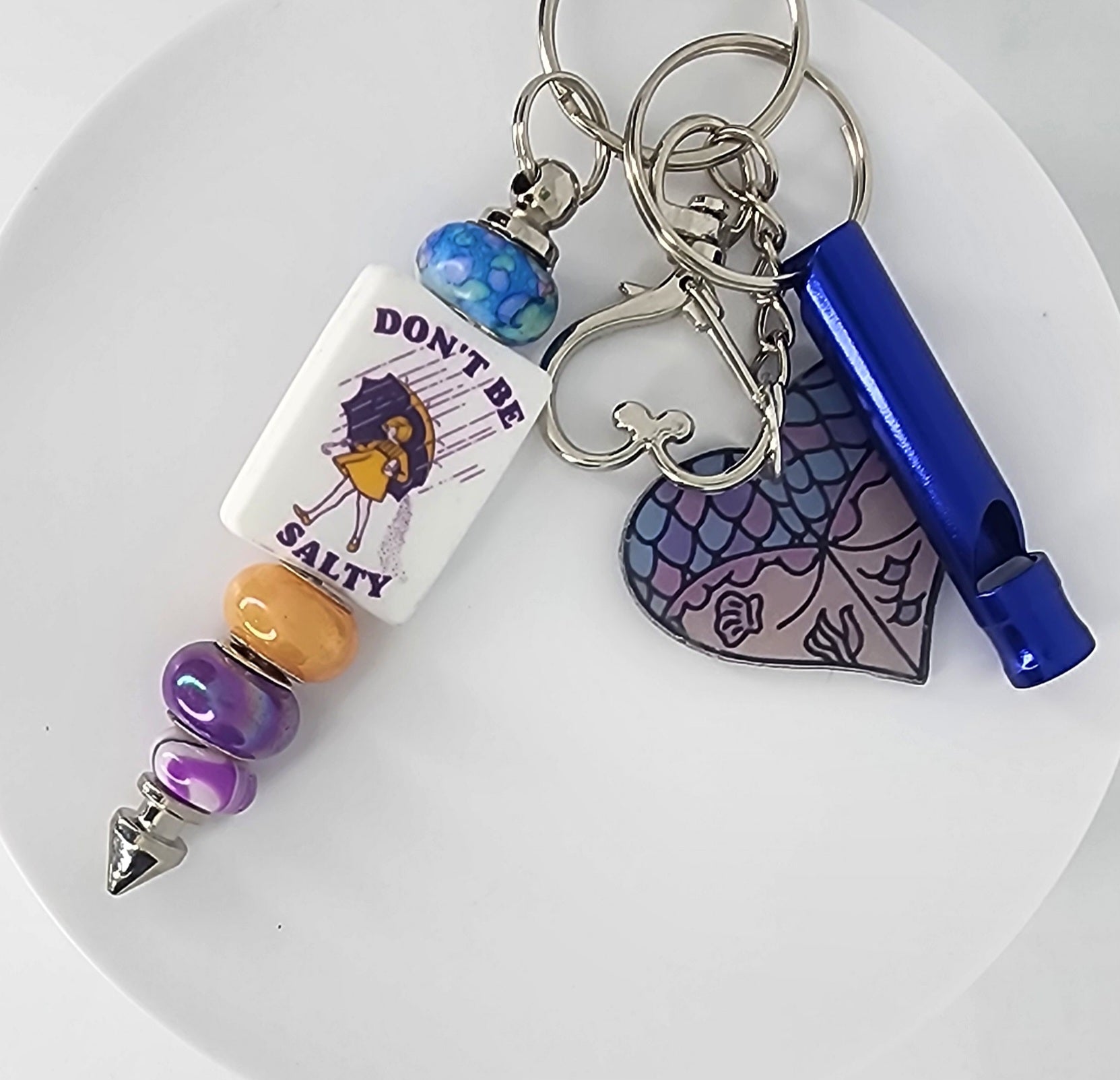 Keychain with colorful beads and charms on a white plate