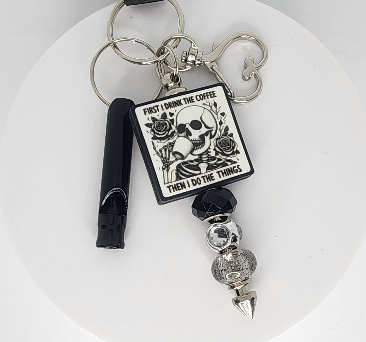 Keychain with skull design and text on a white background