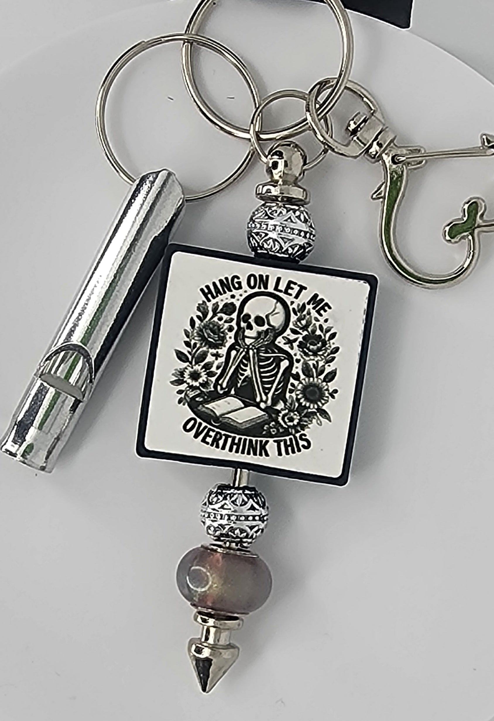 Keychain with skeleton design that says Hang On Let Me Overthink This on a white background