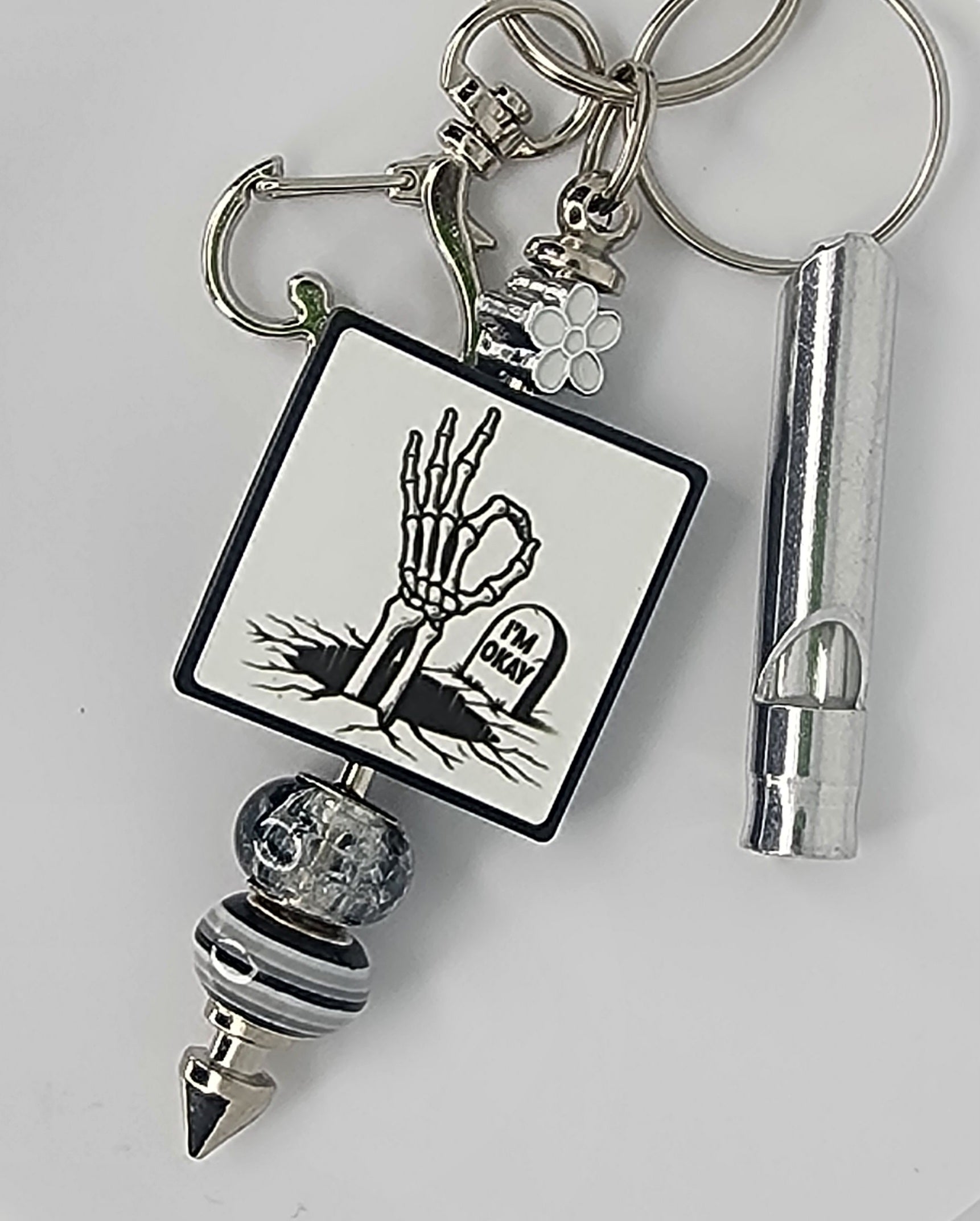 Keychain with a skeletal hand making the OK sign, with a headstone that says "I'm Okay".  Also has a whistle.