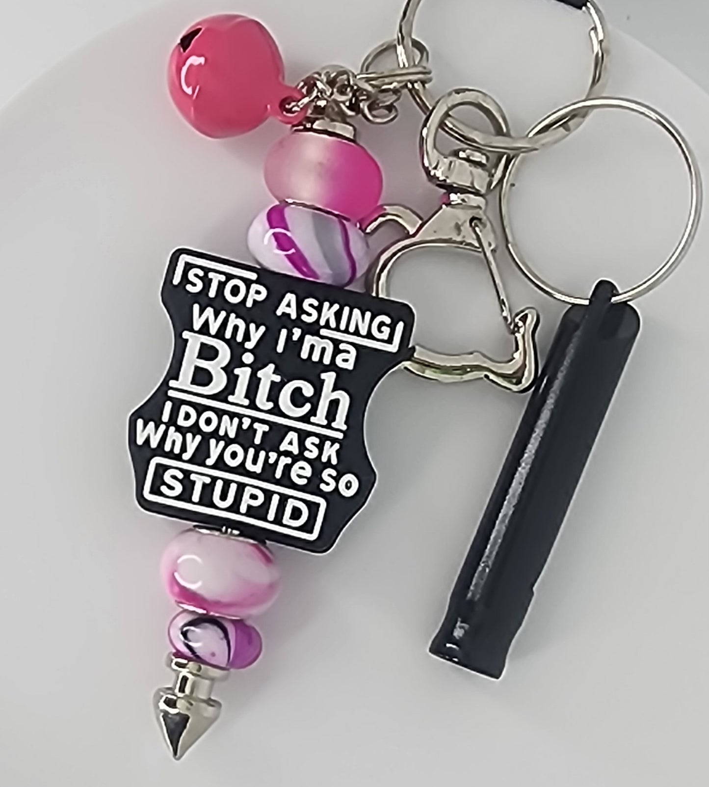 Keychain with pink and purple beads and a black focal bead that says Stop Asking Why I'm a Bitch, I don't Ask Why You're So Stupid on a white background